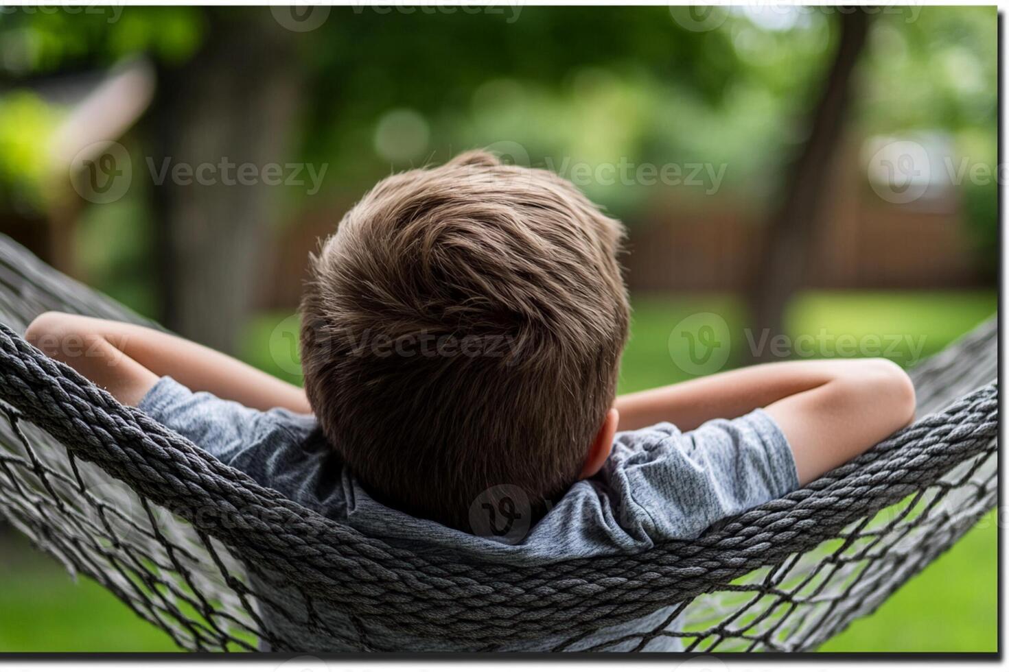 A boy laying in a hammock with his head resting on his arm photo