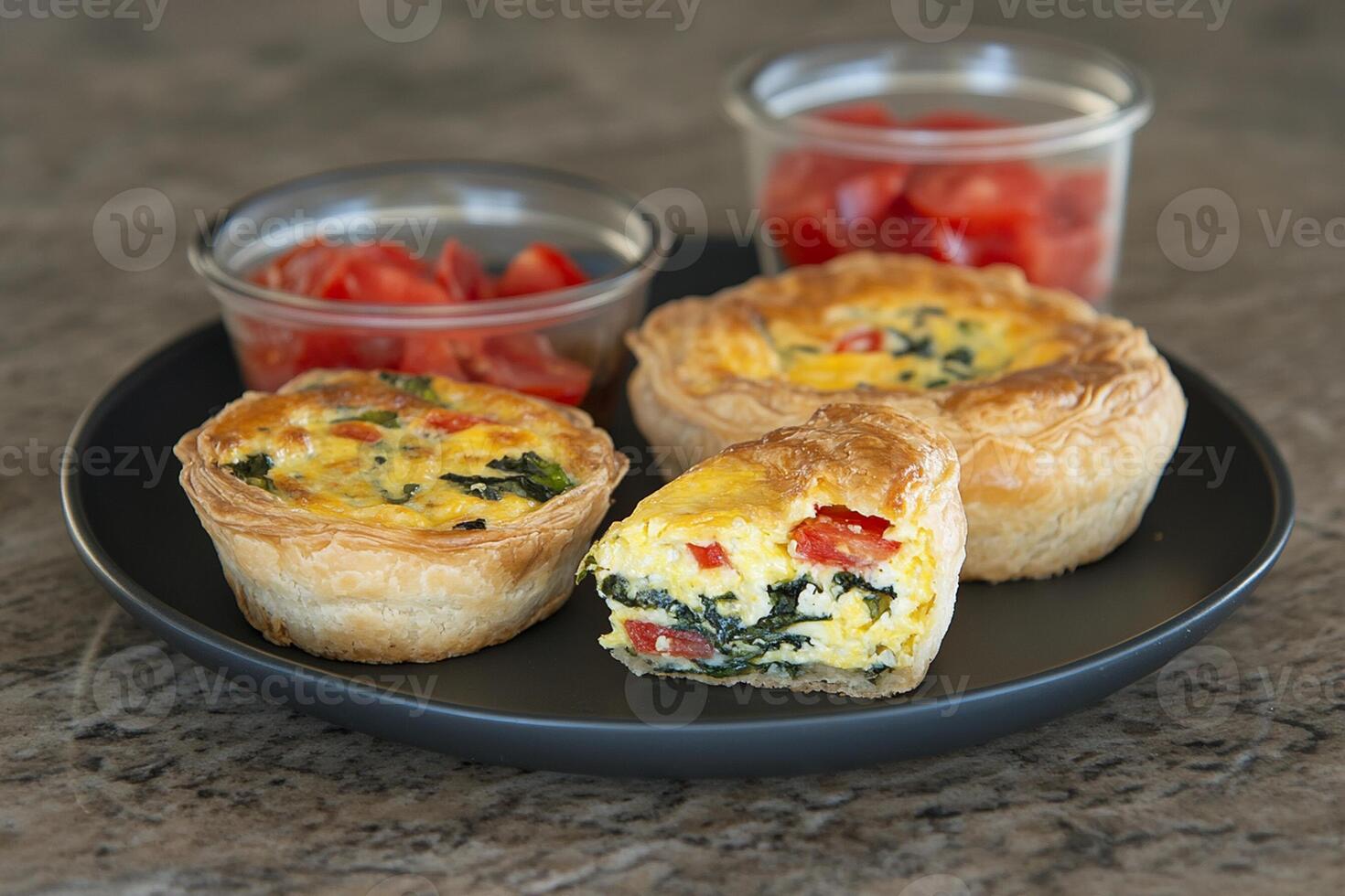 A plate with a quiche and two cups of tomato sauce photo