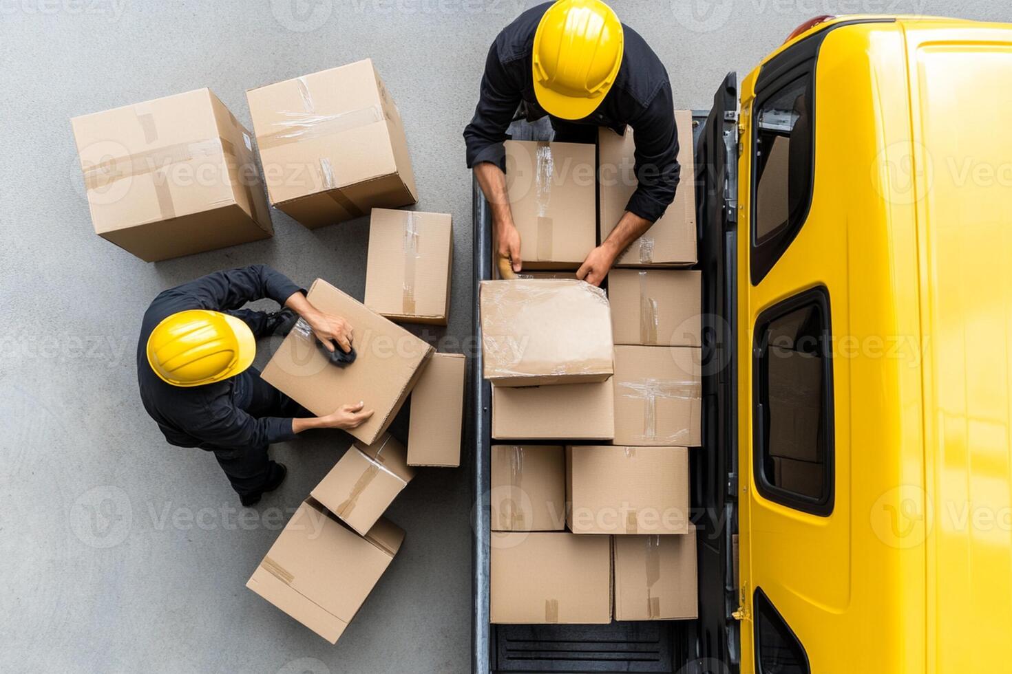 Two men in hard hats loading boxes onto a truck photo