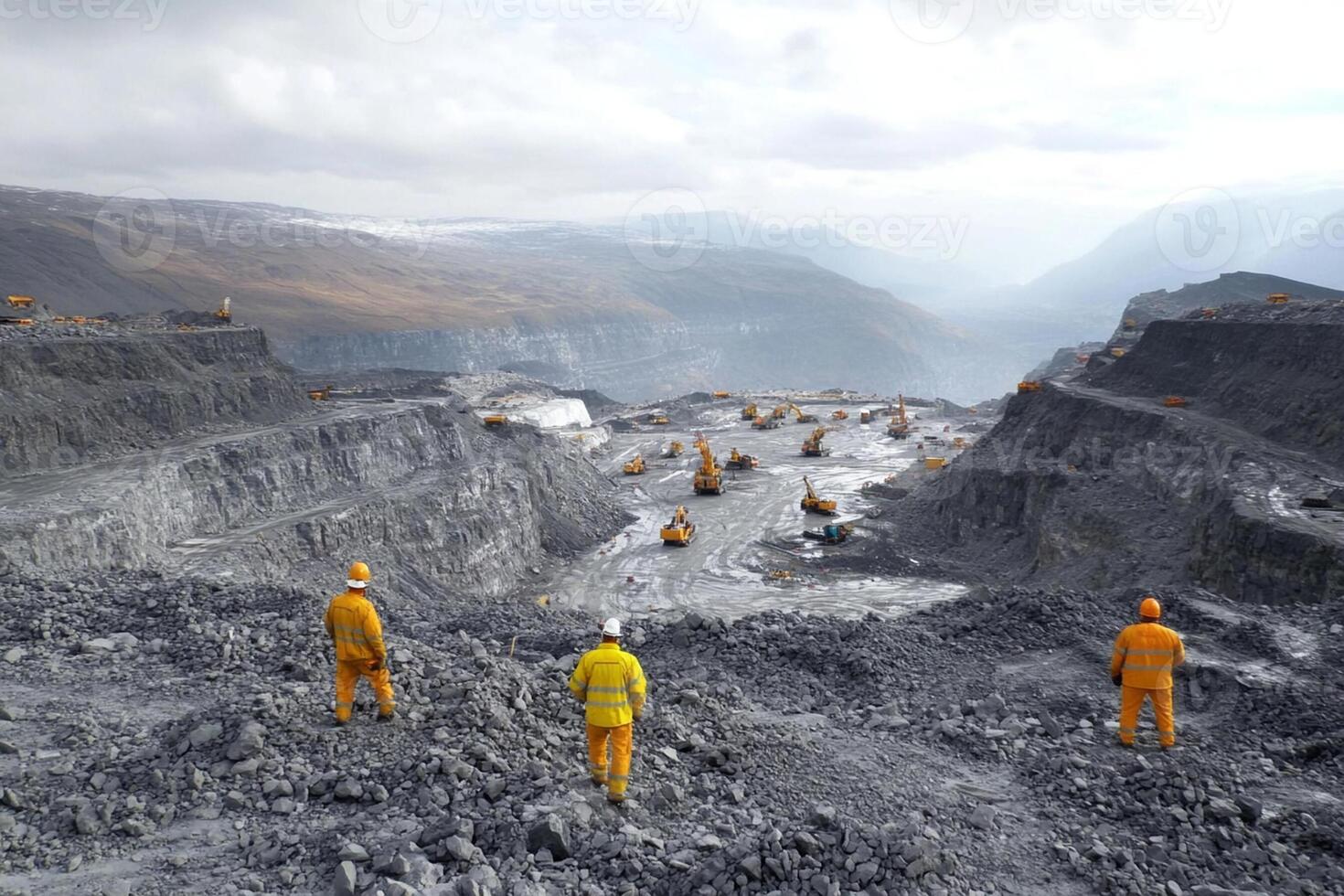 A group of men in orange work clothes standing in a quarry photo