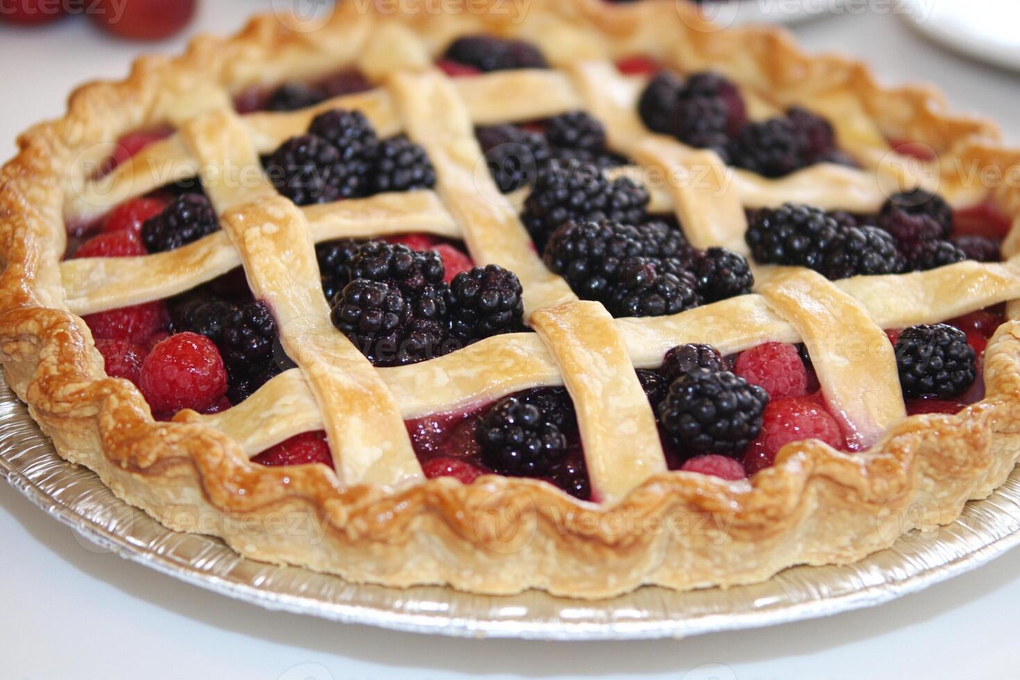 A pie with berries on top and a lattice pattern photo