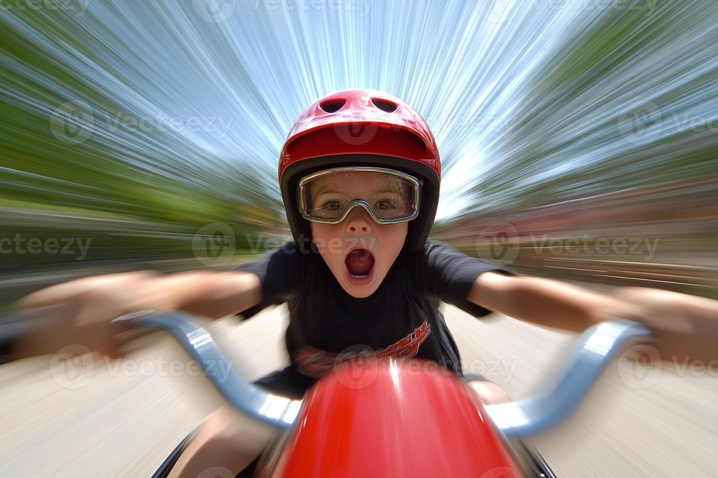 A young boy wearing goggles and a helmet riding a motorcycle photo