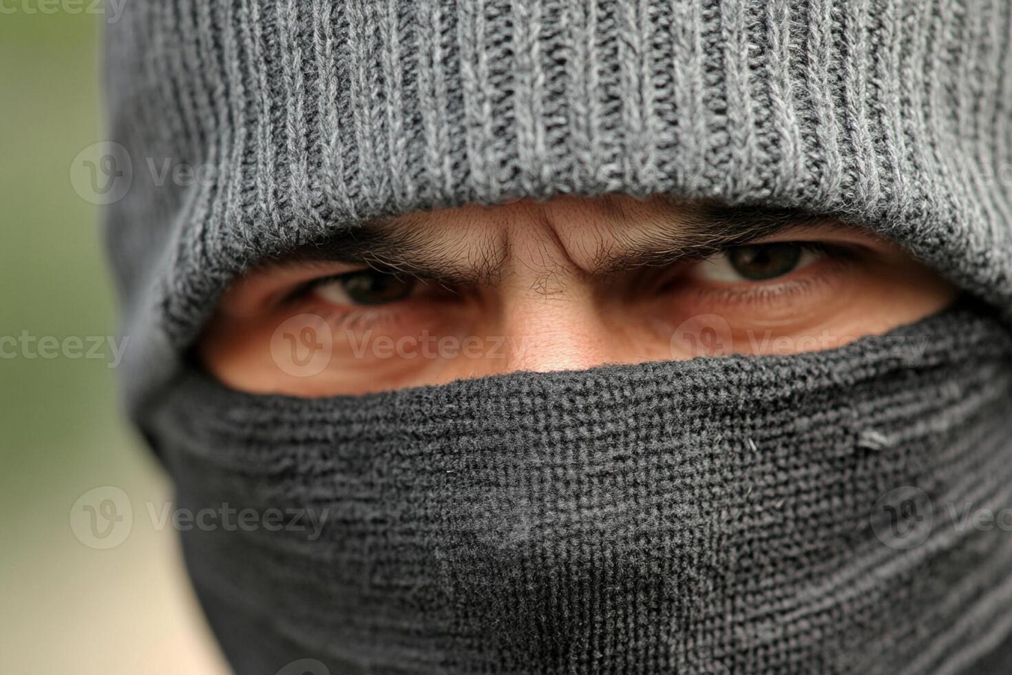 A man wearing a black hat and a gray scarf photo