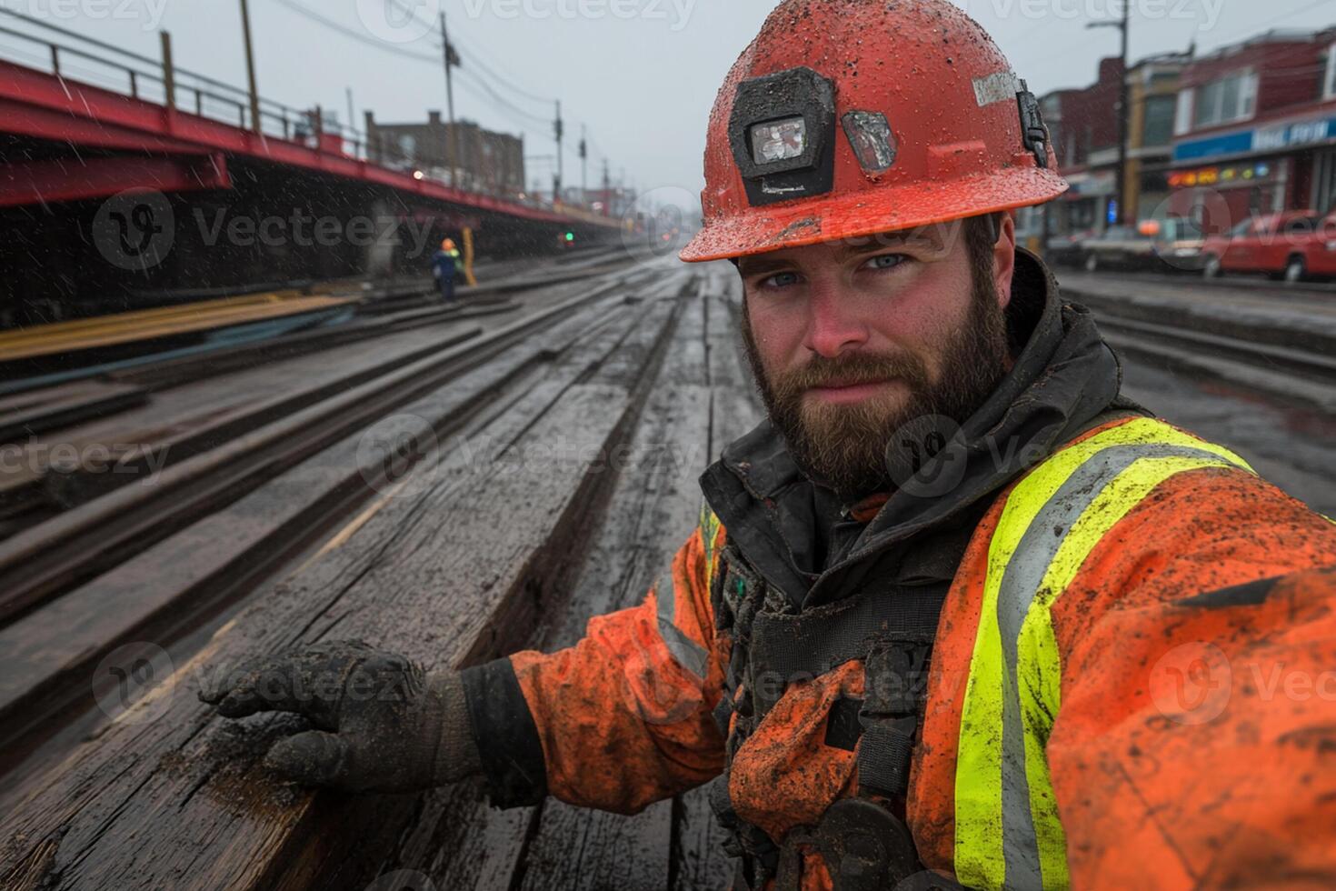 A man in an orange hard hat and safety vest on a railroad track photo