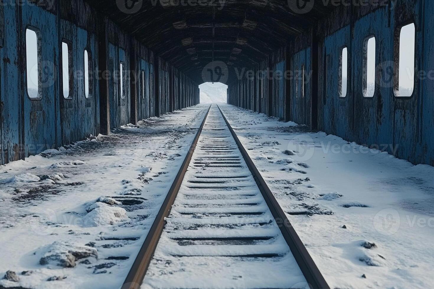 An empty train tunnel with snow on the ground photo