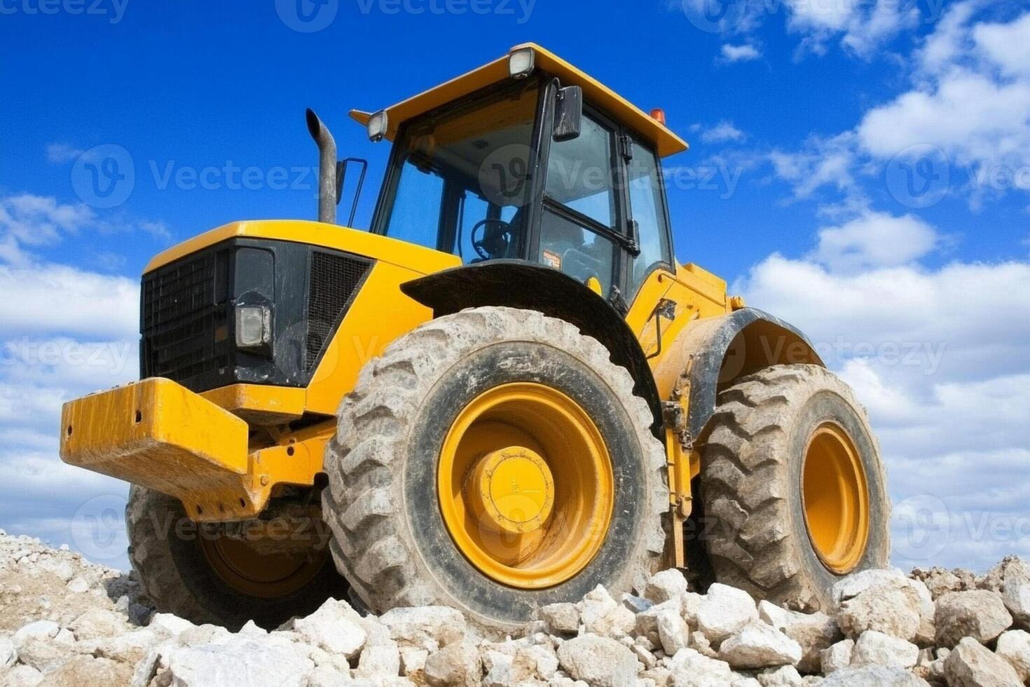 A large yellow bulldozer sitting on top of a pile of rocks photo