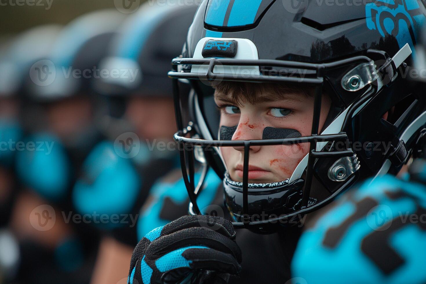 A young football player wearing a helmet and black and blue uniform photo