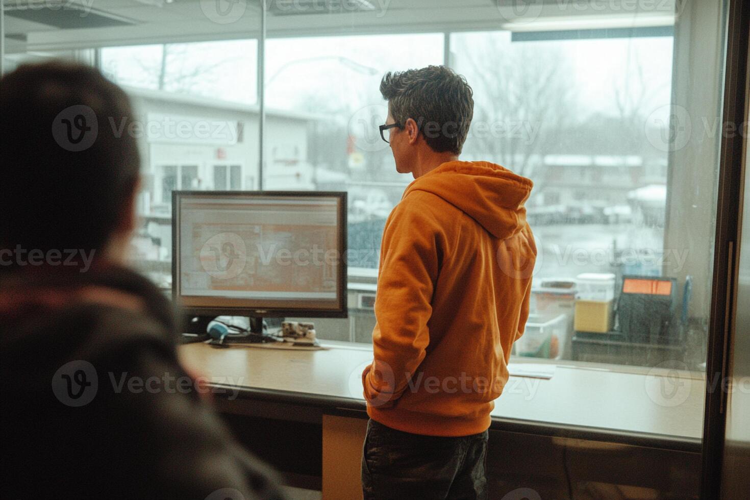 Two men in an office looking at a computer screen photo