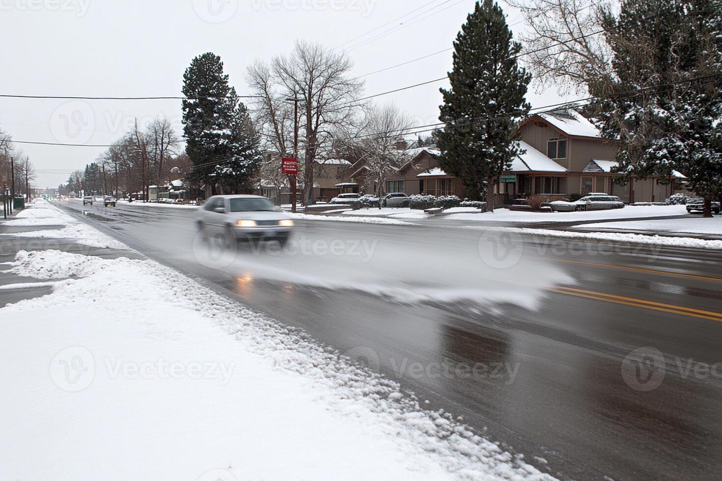 A car driving down a snowy street with snow on the ground photo