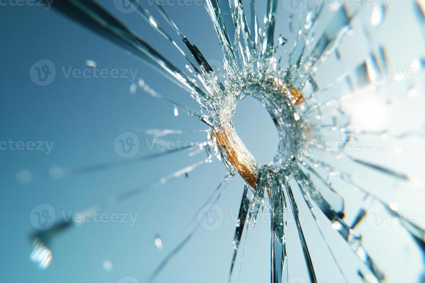 A bullet hole in a glass window with a blue sky photo