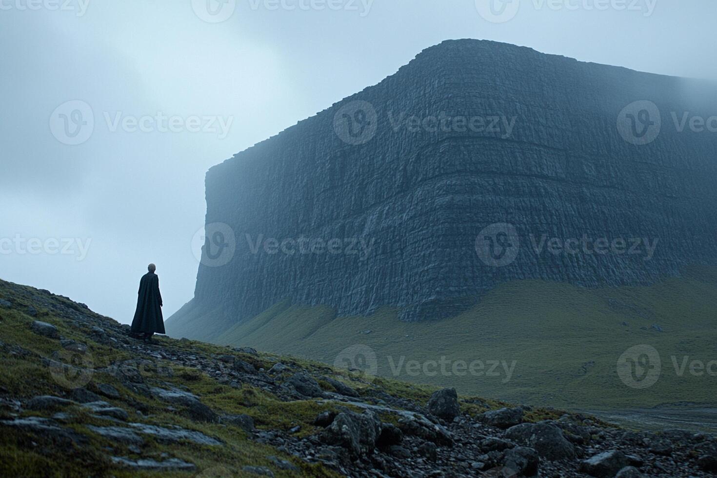 A person standing on a mountain in the fog photo
