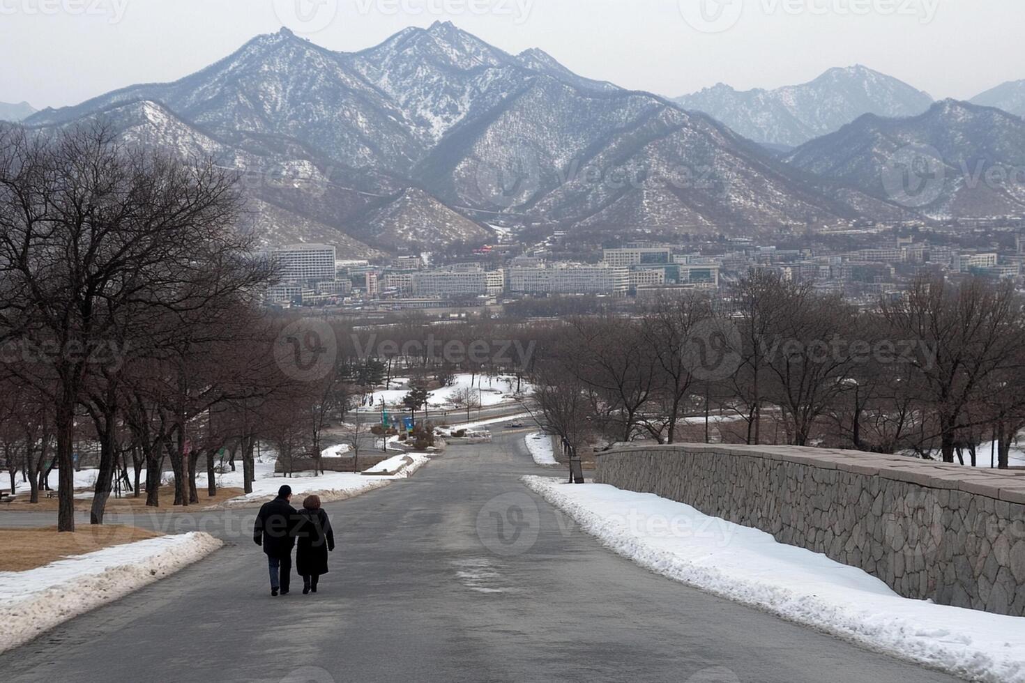 A couple walking down a road with mountains in the background photo