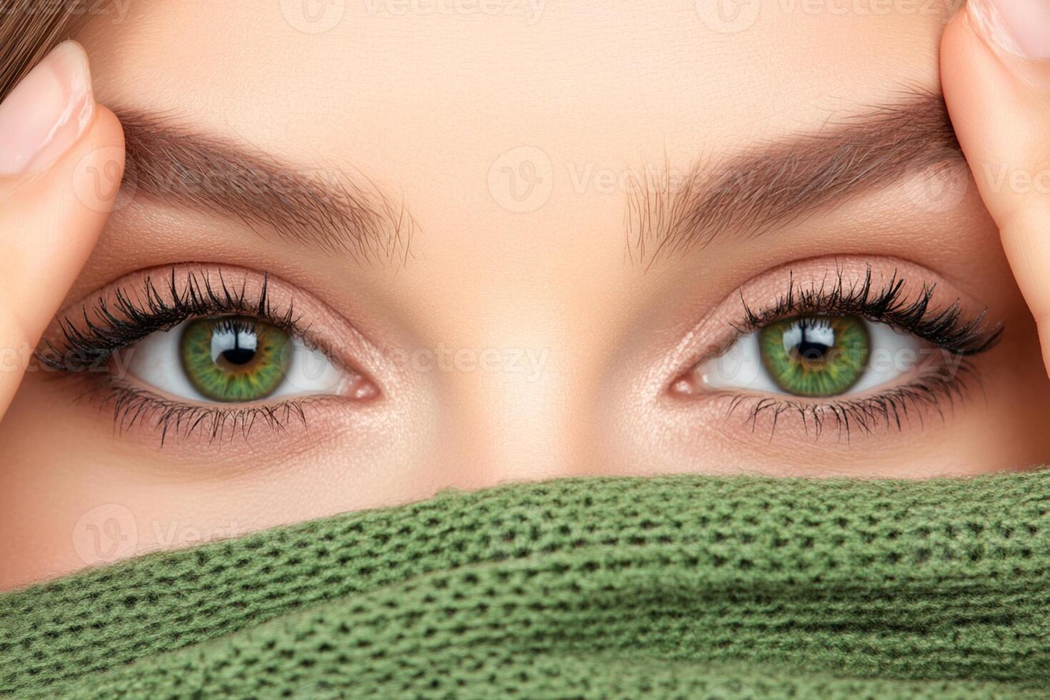 A woman with green eyes covering her face photo