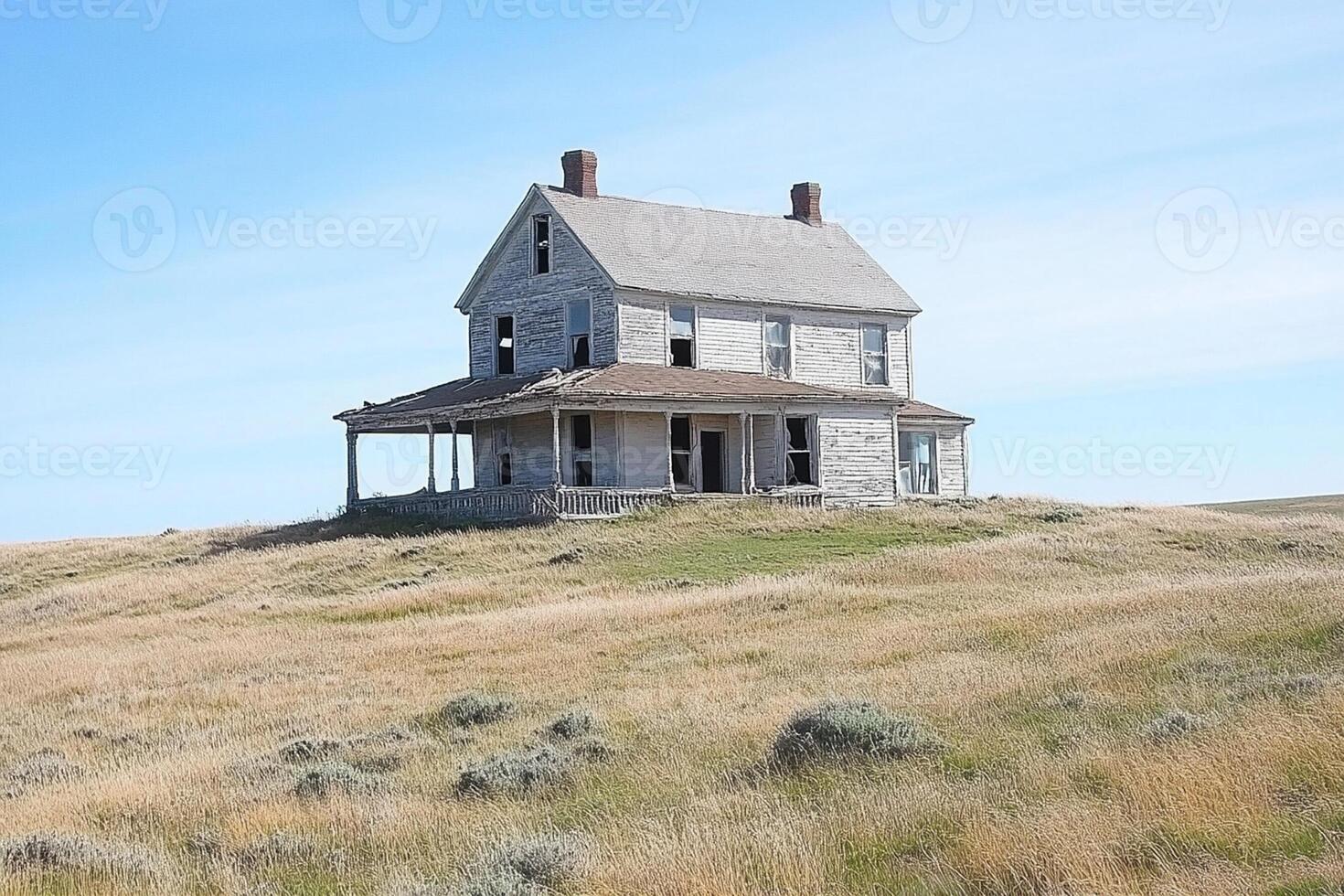 An old abandoned house sits on a hill in the middle of nowhere photo