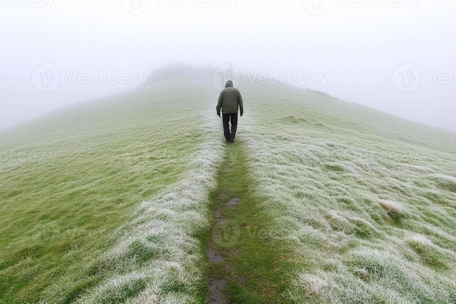 A man walking on a path in the fog photo