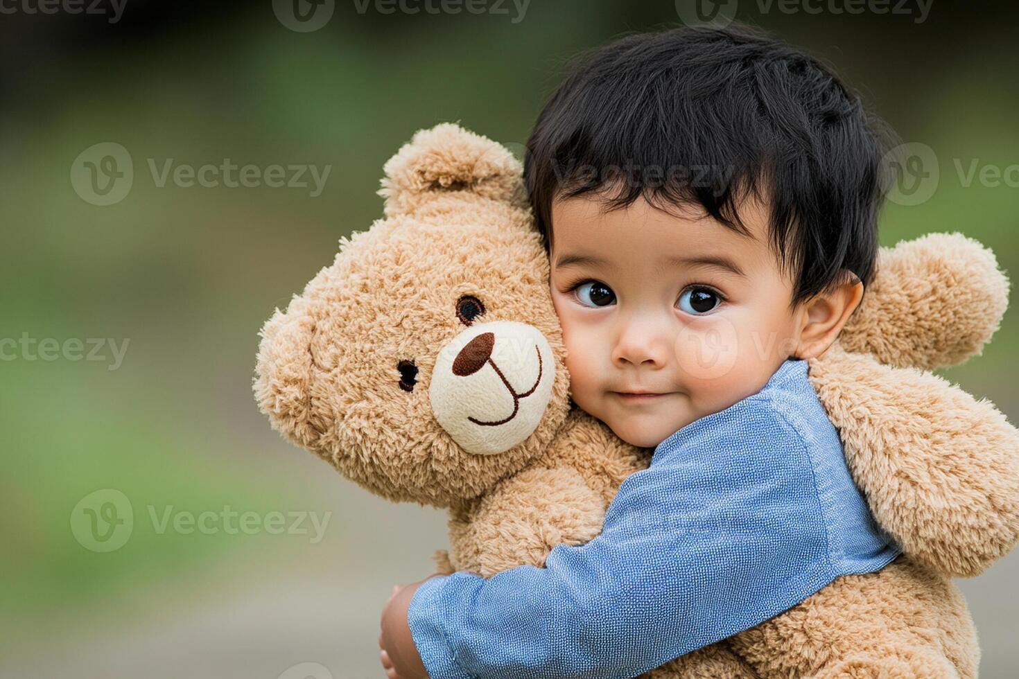 A young boy is holding a teddy bear photo