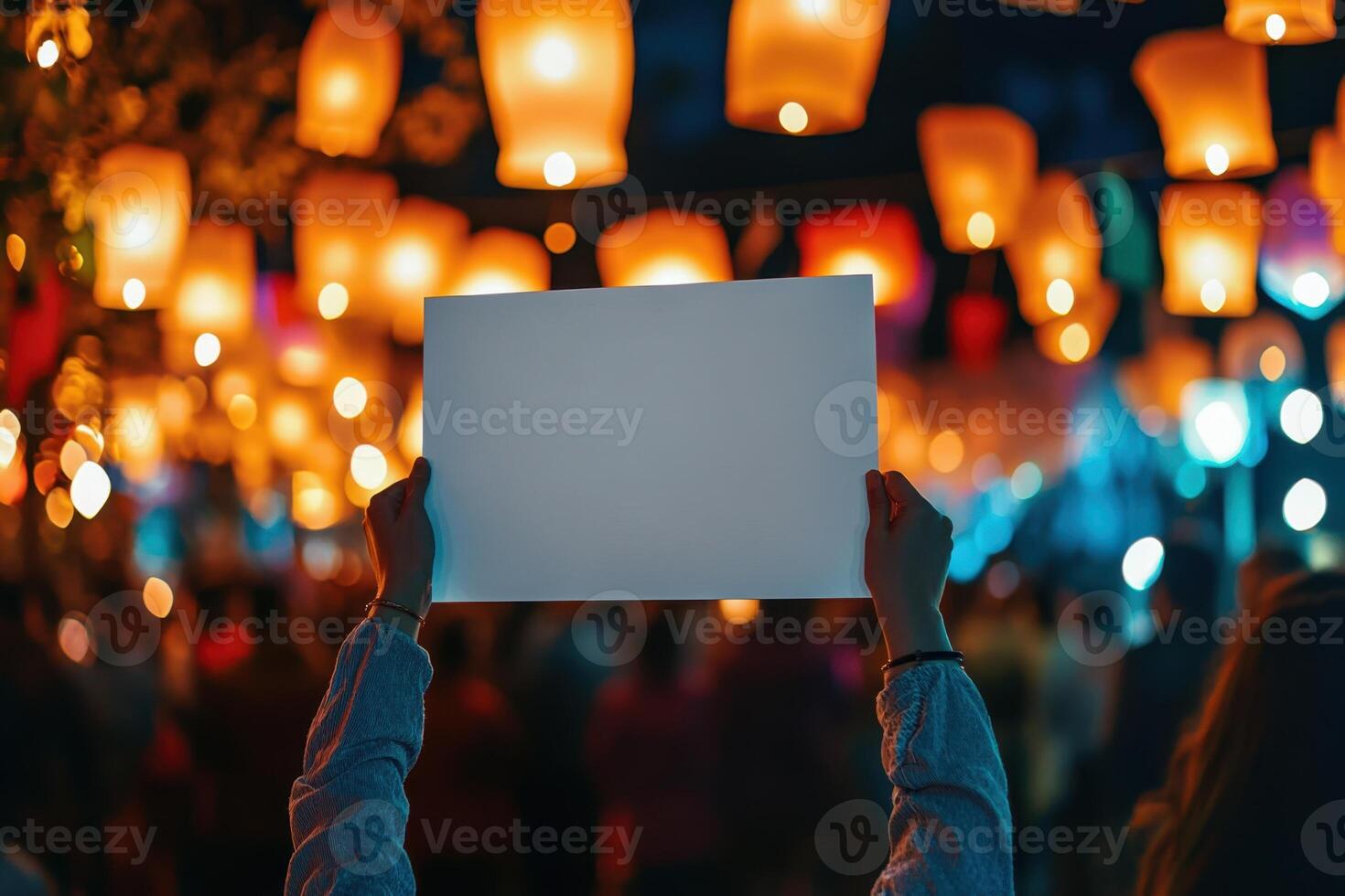 A person holding a blank piece of paper in front of a crowd of people photo