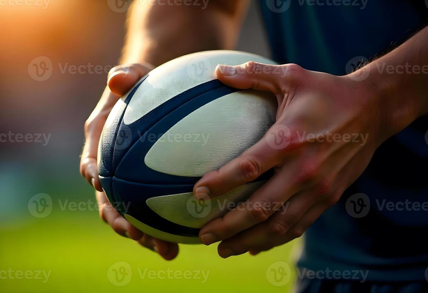 Detailed Close-Up of a Person Handling a White Rugby Ball Adorned with Dark Blue Accents in a Dynamic Outdoor Setting photo