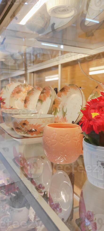Side view of multiple ceramic plates and mug on displays in dishware store. photo
