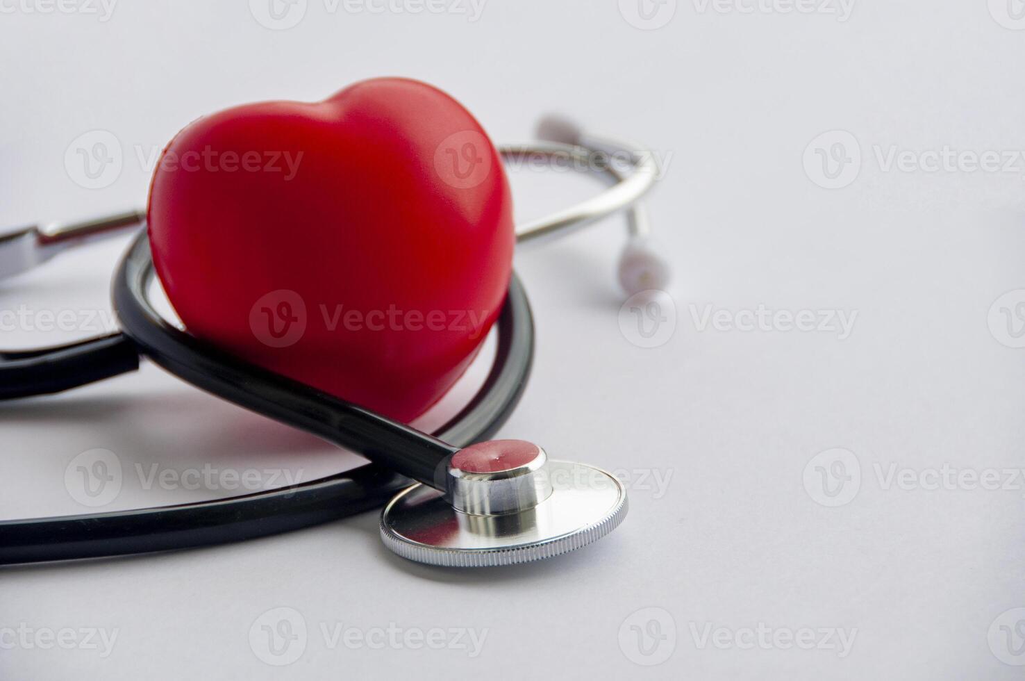 Close up view of stethoscope with red hearts shape on white background with customizable space for text. Medical and health concept. photo
