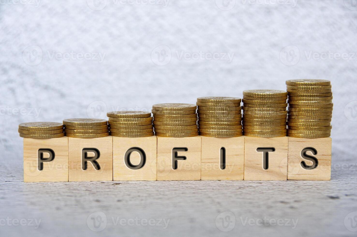 Profits text on wooden cubes with stacking golden coins. Business concept photo