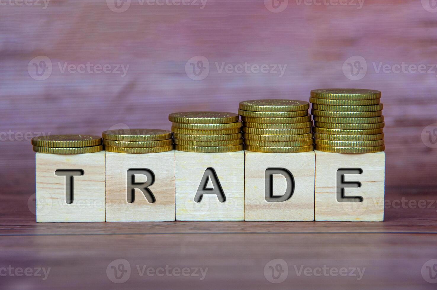 Trade text on wooden cubes with stacking golden coins. Business concept photo