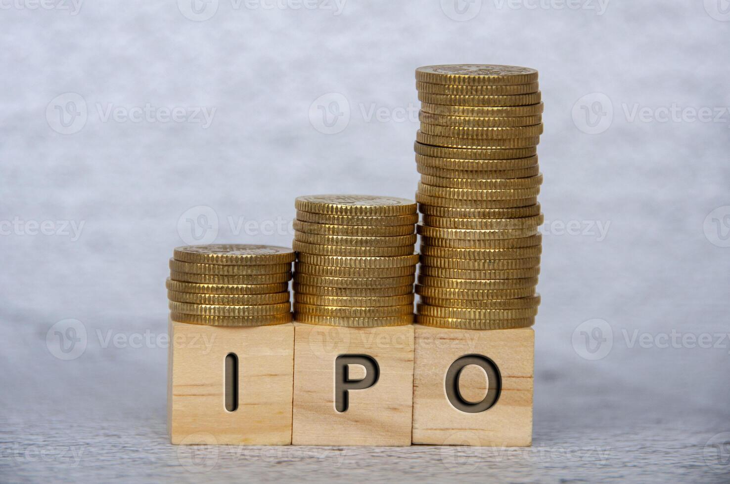 Initial Public Offering text on wooden cubes with stacking golden coins. IPO and investment concept photo