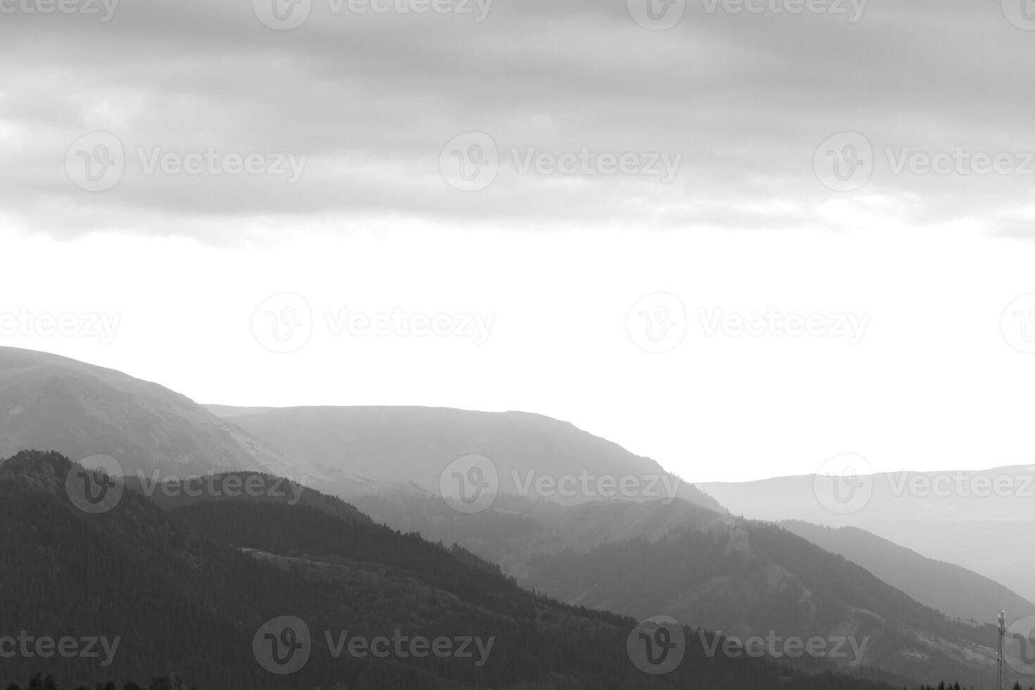 Black and white landscape of the mountain range with partly cloudy sky photo