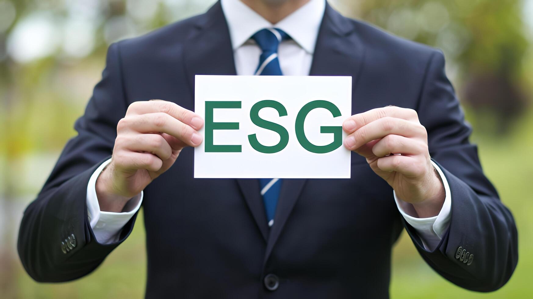 Businessman holding ESG sign outdoors showcasing corporate social responsibility in a natural photo