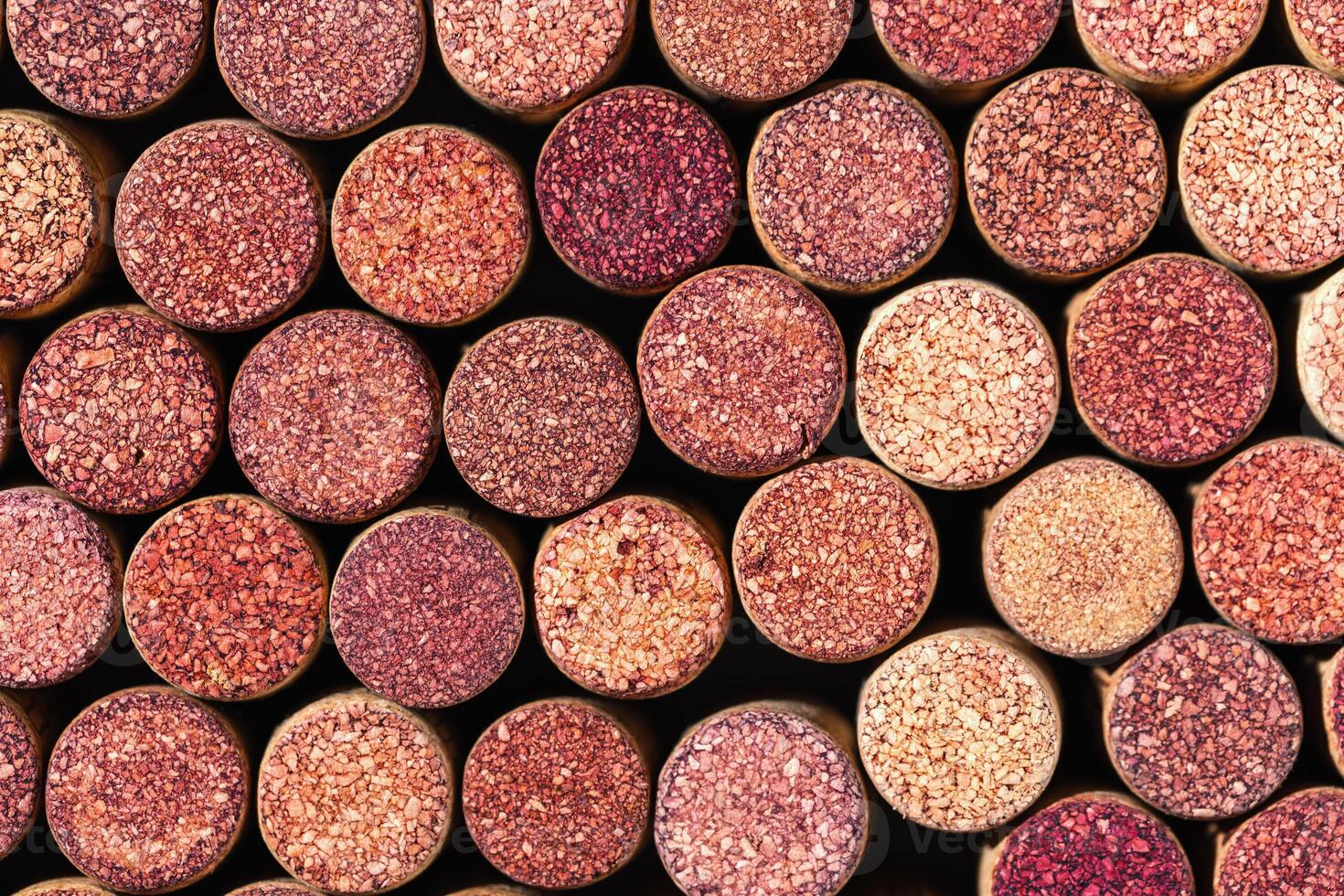 Wine cork background from red wine, natural texture used bottle stoppers top view. Closeup wooden red stain corks. Natural textured stoppers colored wallpaper. Bright background wine corks photo