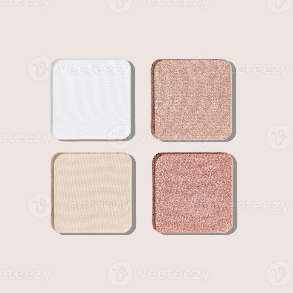 Eyeshadow neutral palette, mix of glitter, matte shades in beige, brown, white hues. Minimal top view pattern for beauty, makeup, cosmetic themes, Textured swatches eyeshade or highlighter refills photo