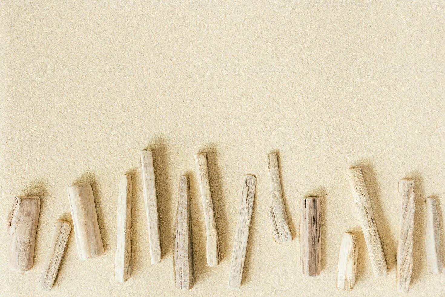 Aesthetic minimal pattern from old pieces of wood on sand, beautiful sandy texture, natural background, concept of harmony, balance and meditation, relaxation. Top view, summer flat lay photo