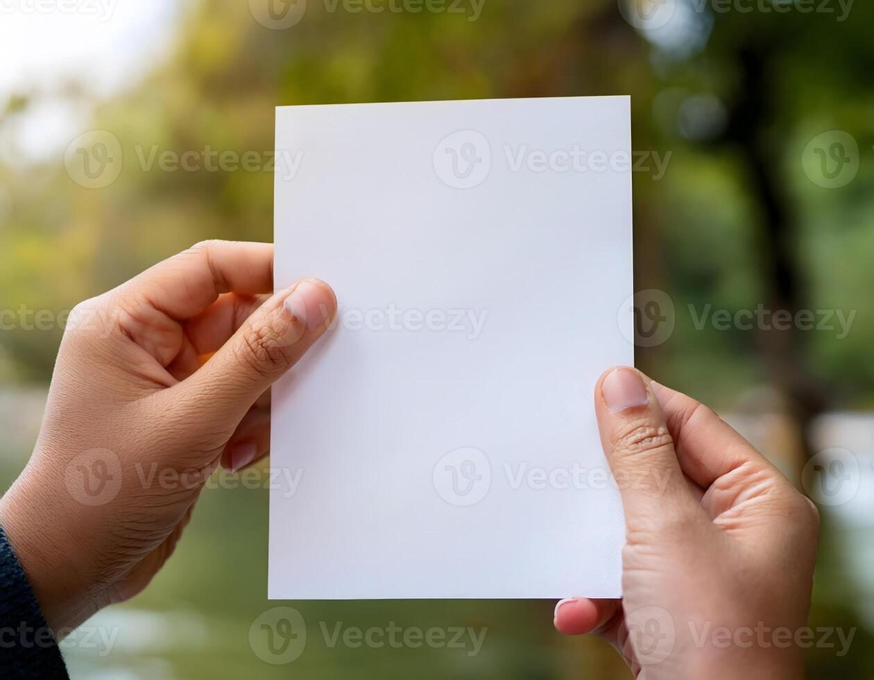 Person Holding Plain Paper with Bokeh Background photo