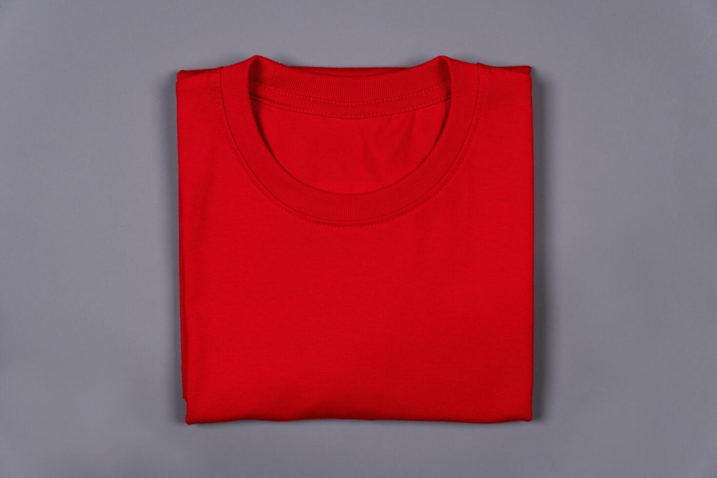 Red folded t-shirt against a grey background photo