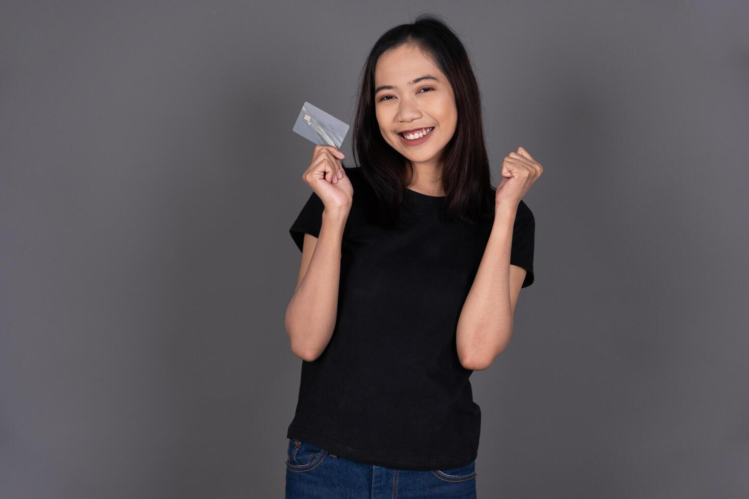 Portrait of a Female Smiling While Holding a Credit Card Isolated photo