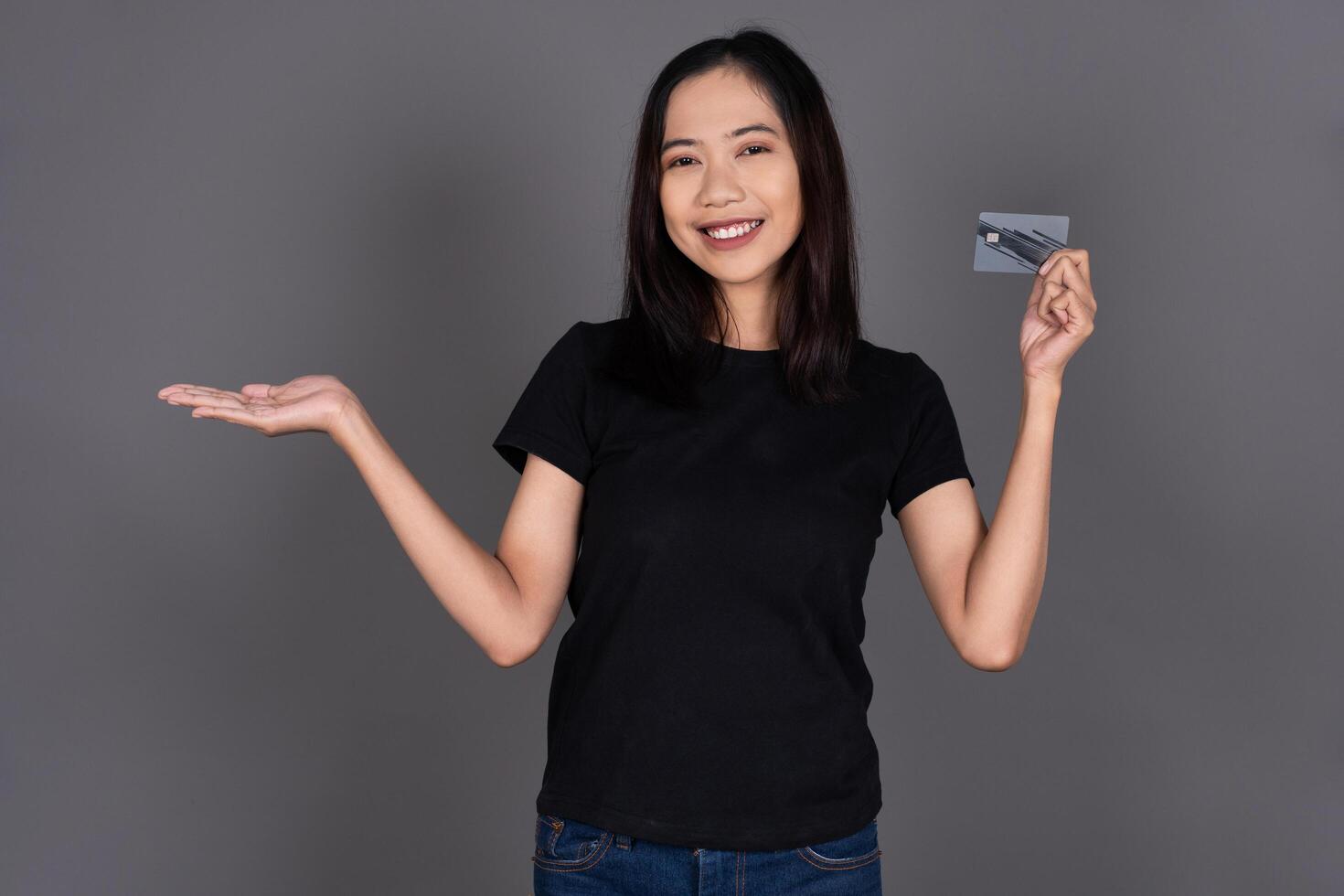 Portrait of a Girl Smiling While Holding a Credit Card Isolated Background photo