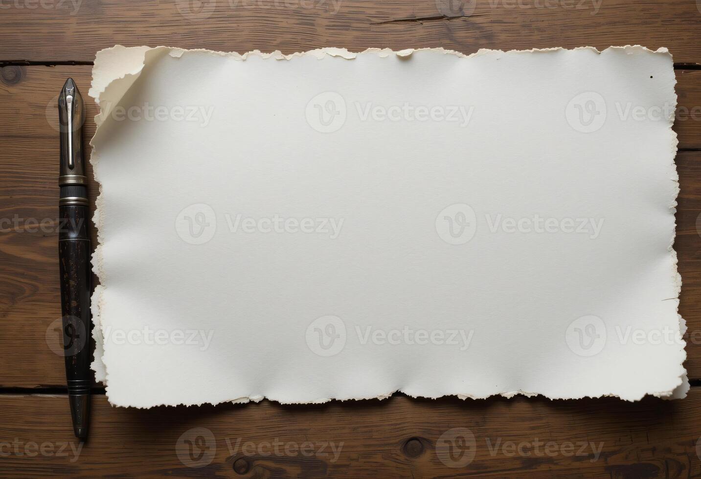 A blank slightly torn white paper on brown wooden table with an old fountain pen beside photo