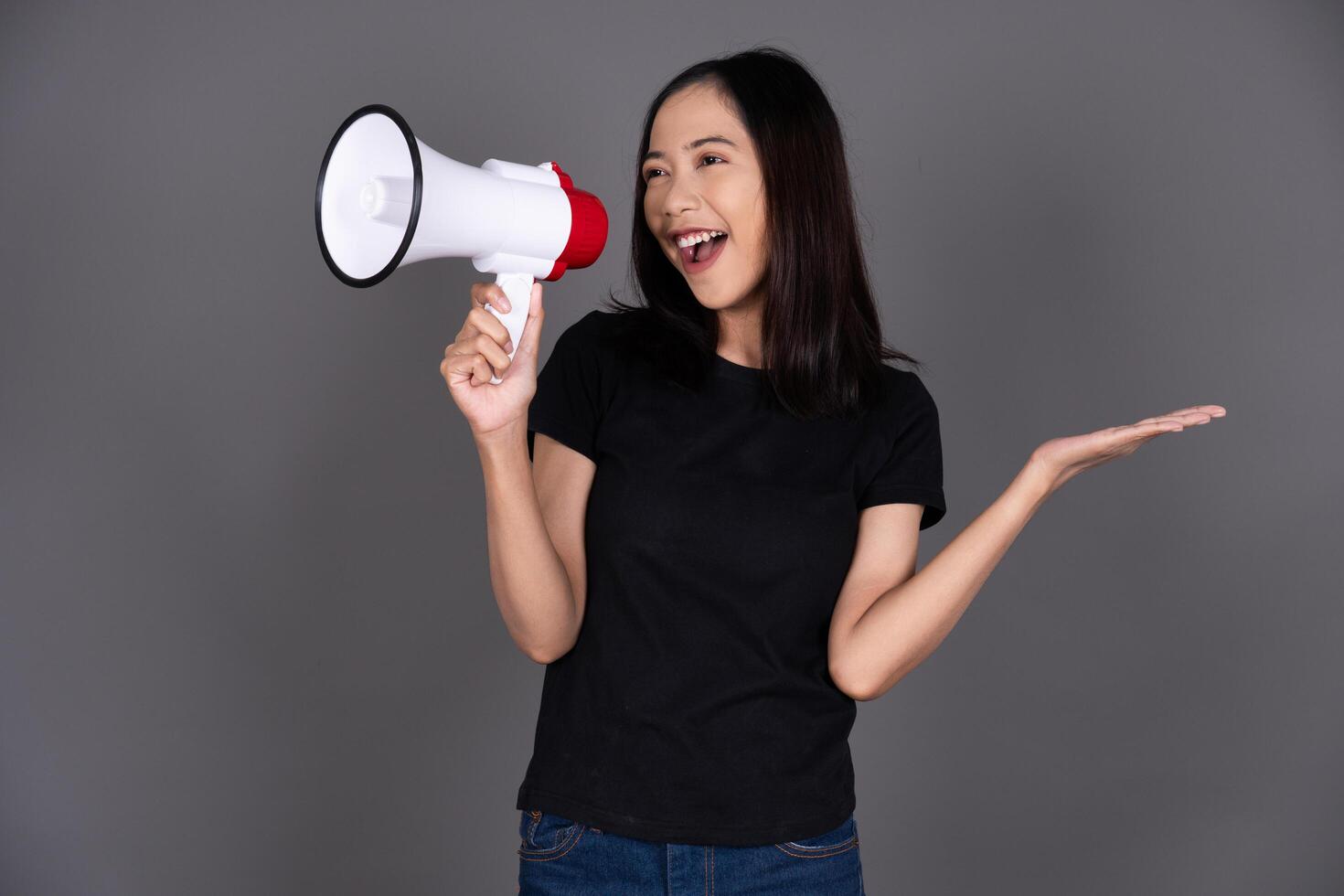 Portrait of a Young Woman Holding a Megaphone and Speaking Out Isolated photo