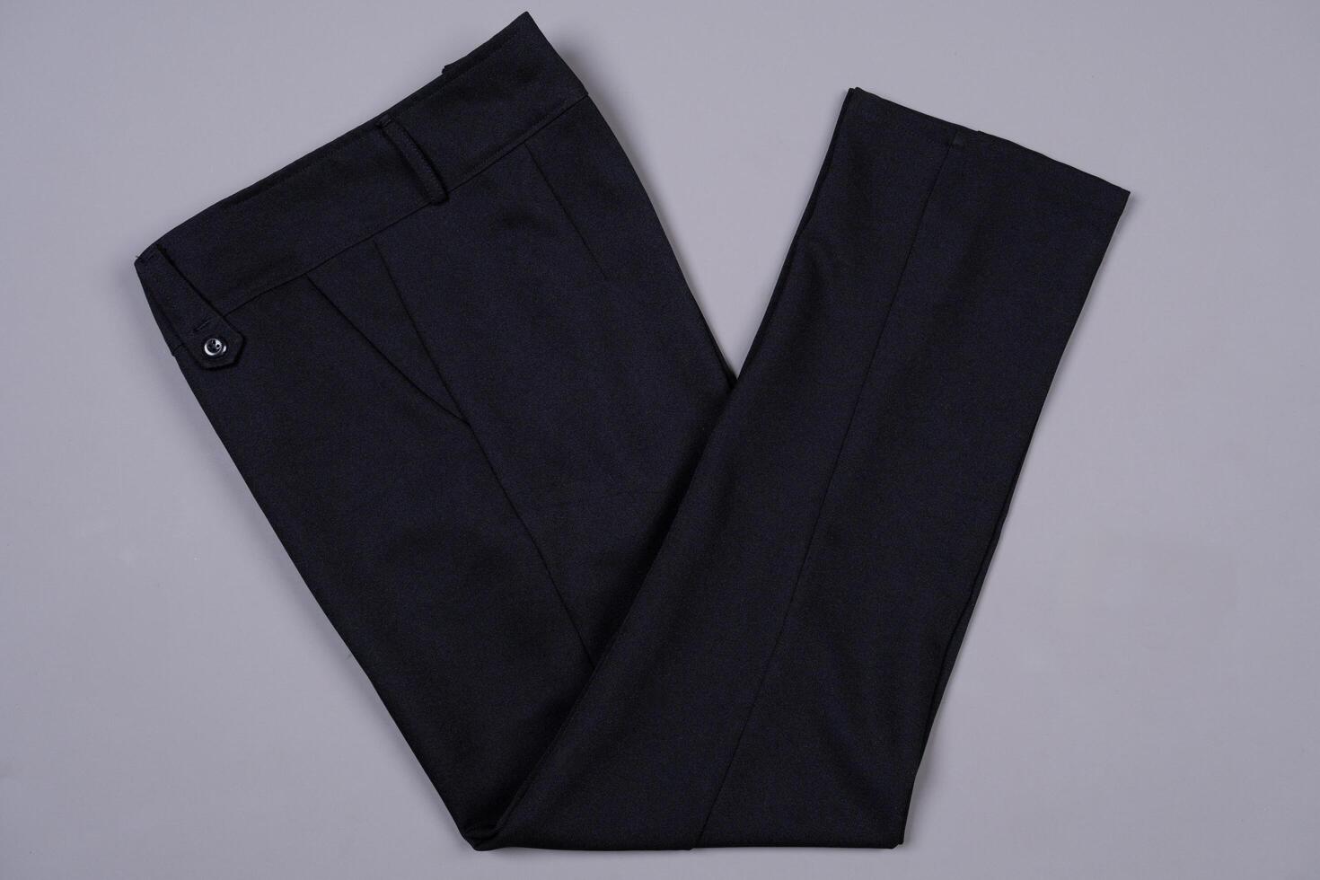 Black folded pants on a grey background photo