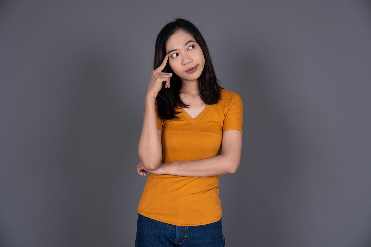 Portrait of a Young Woman Thinking, Looking Confused and Pensive Isolated photo