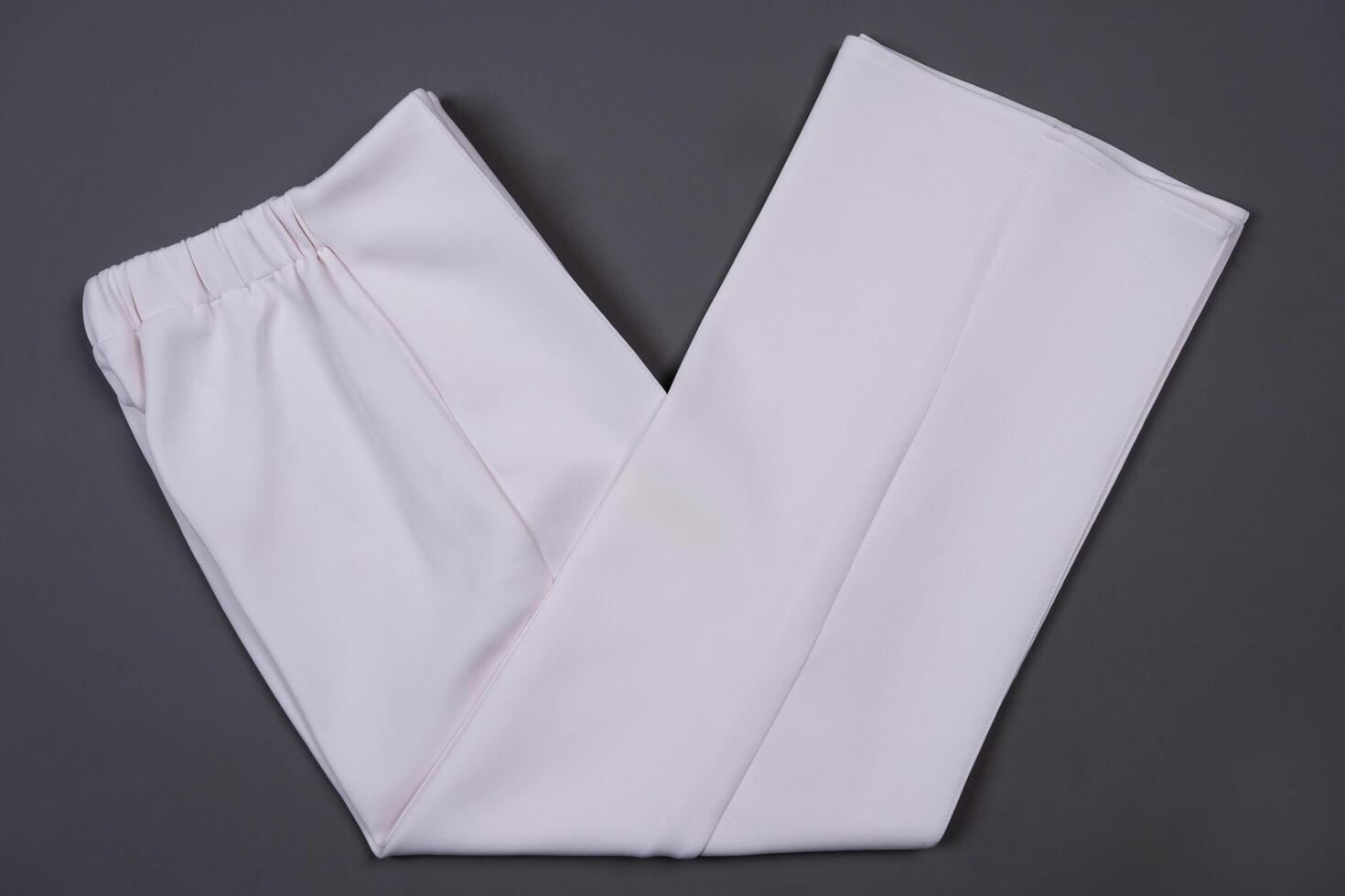 White folded pants on a grey background photo