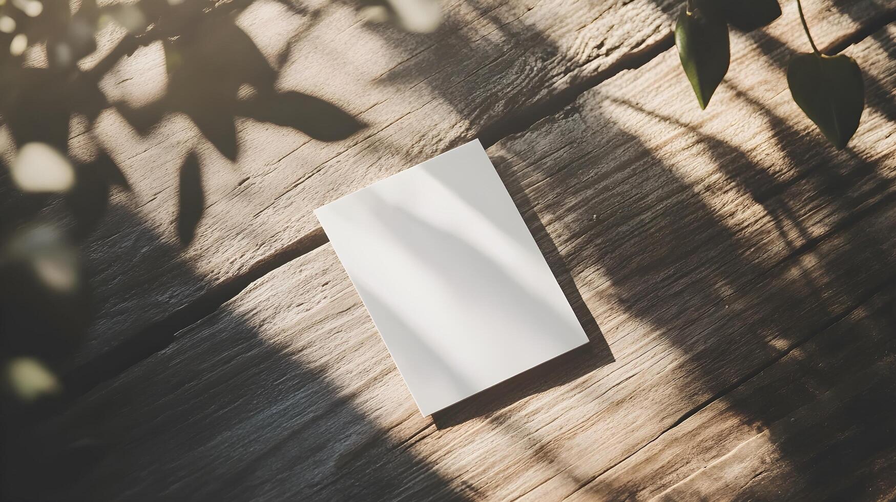 blank white card mockup on wooden surface with sunlight and shad photo