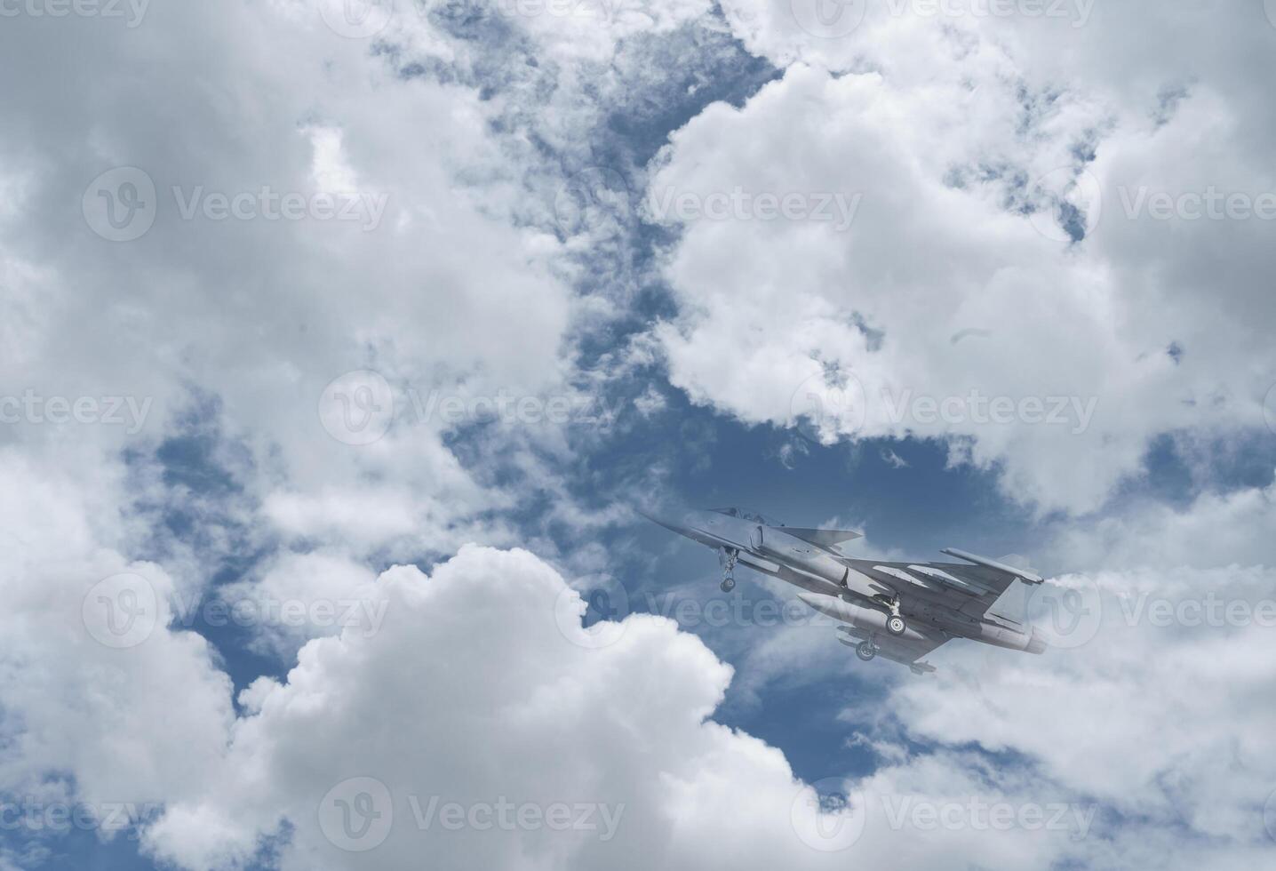A fighter jet flying through the sky with clouds photo