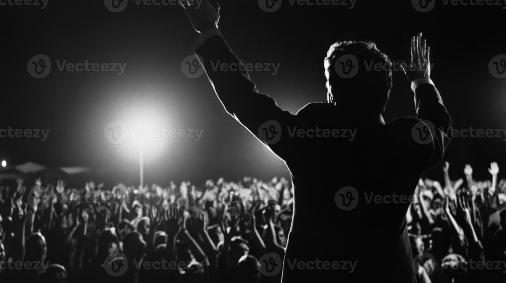 The politician midspeech displays a blend of emotion with a slight tear in their eye showcasing the weight of the moment. Silhouettes of supporters can be seen in the background raisin photo