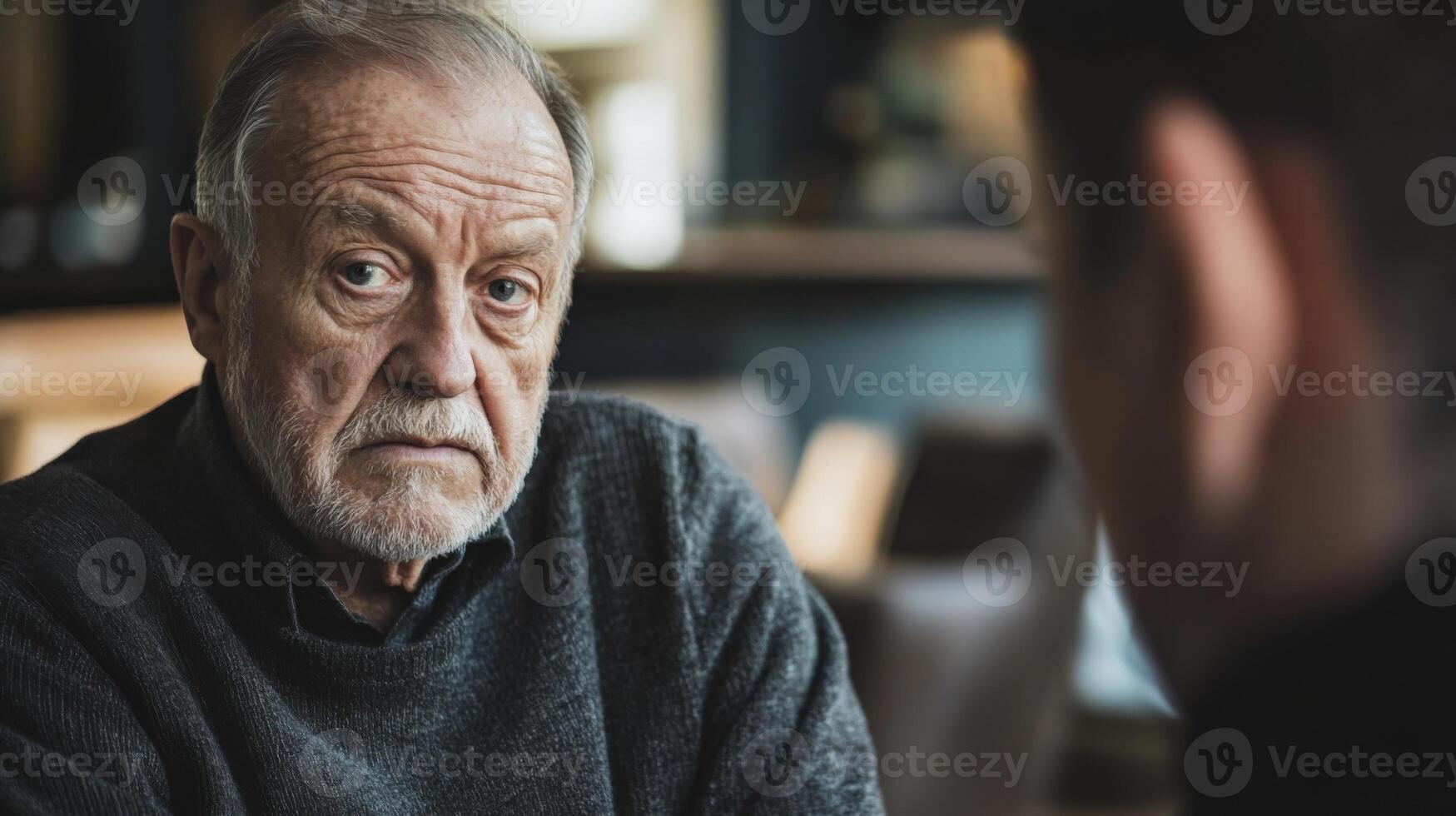 Senior politician listening attentively during meeting with blurred colleague photo