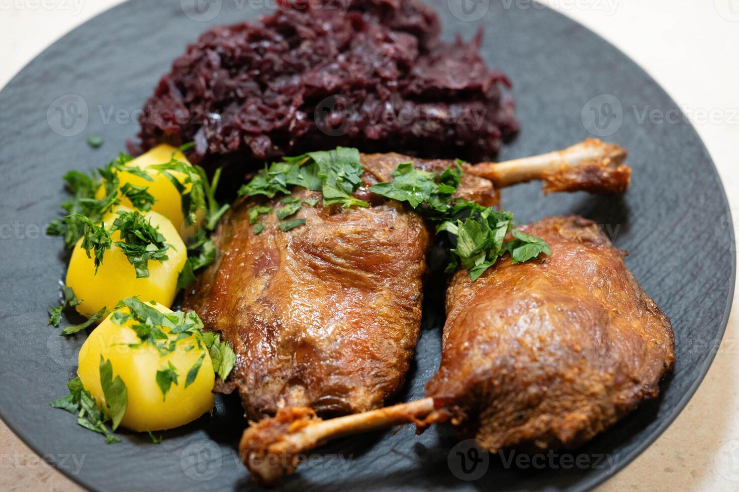 Two fried duck legs with red cabbage photo