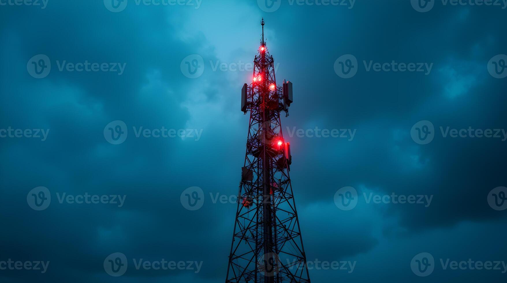 A cell tower with red lights on it in front of a dark sky photo
