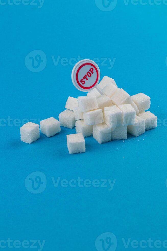Sugar cubes piled with a warning sign against excessive consumption photo