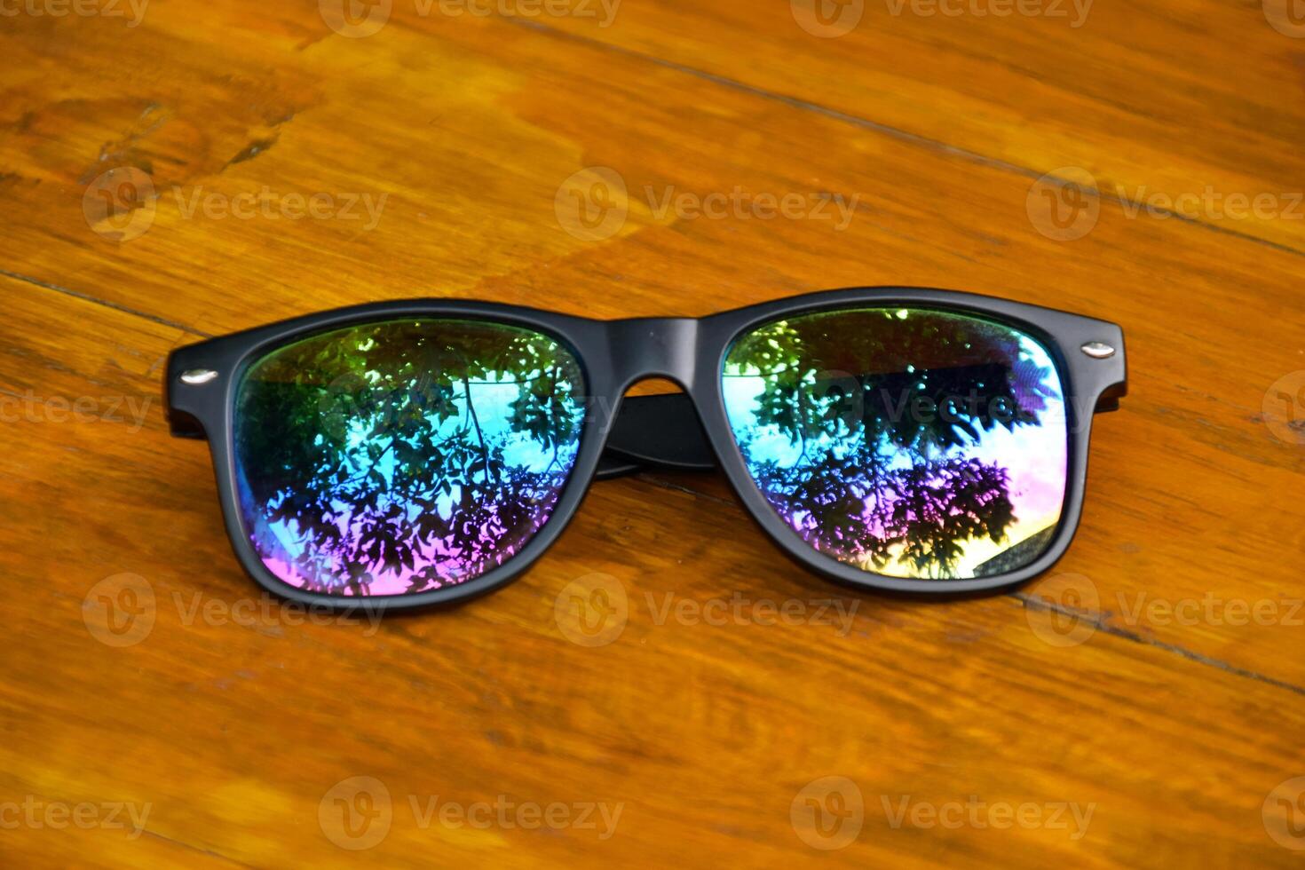 Detailed View of Black Sunglasses on Wooden Table photo