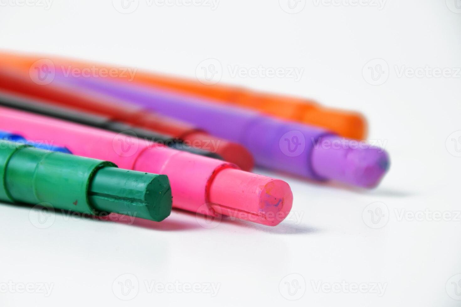 Multicolored silky crayons on white background photo